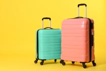 Blue and pink luggage with a yellow background