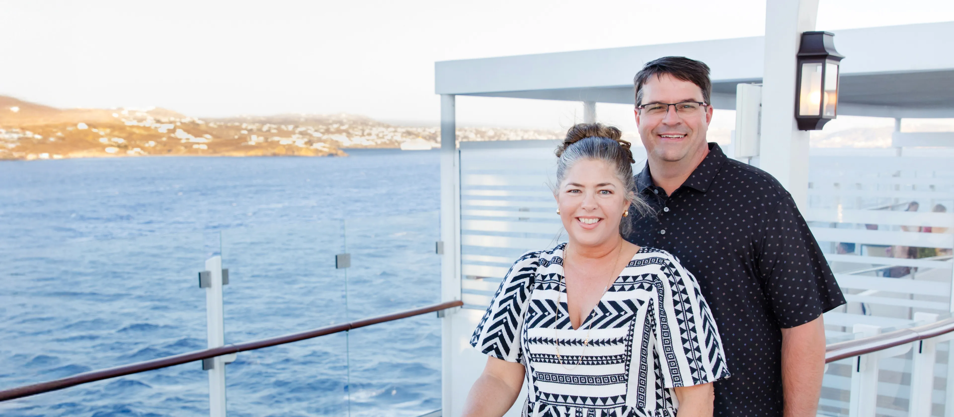 A couple standing on the deck of a ship