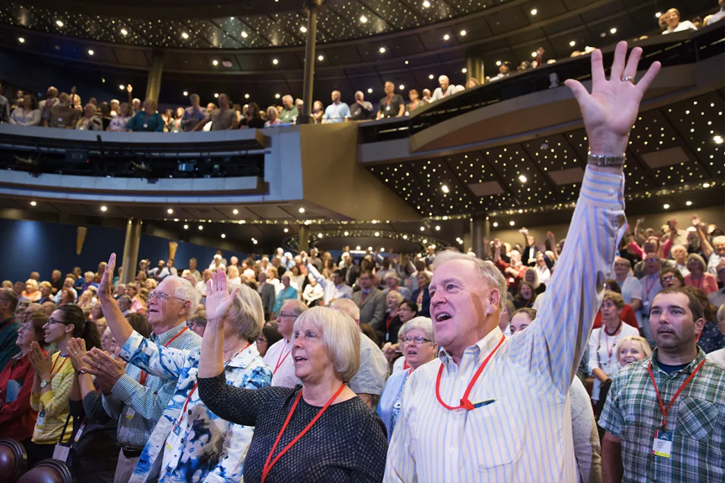 Group of people singing with lifted hands