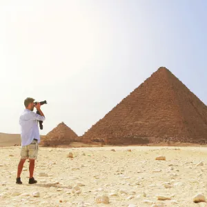 man pointing camera at pyramid