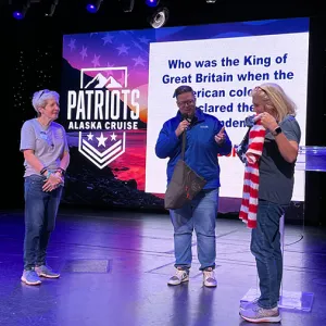 People standing on a stage at a Patriots Alaska Cruise event